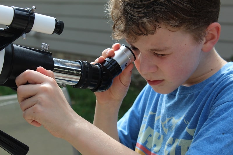 best telescope for kids - closeup of kid looking through eyepiece