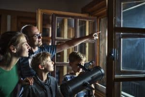 Family and kids using telescope