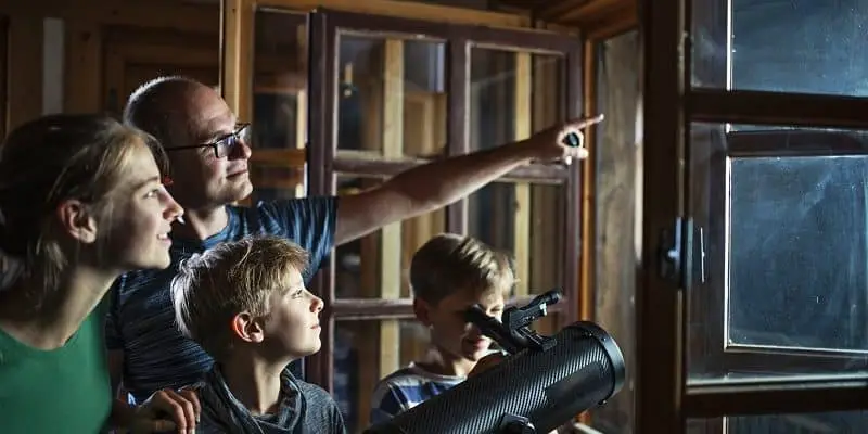 Family and kids using telescope