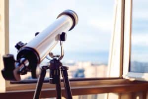 refractor telescope looking out of a window
