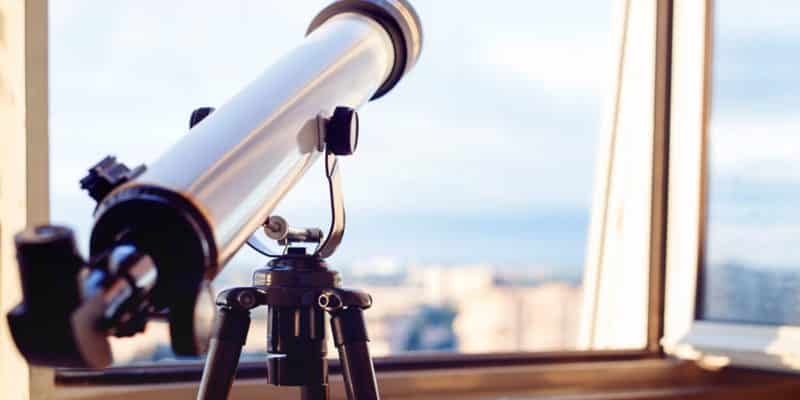 refractor telescope looking out of a window