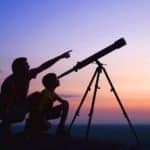 boy and father looking through a telescope