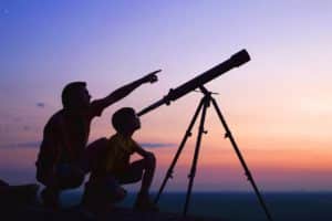 boy and father looking through a telescope